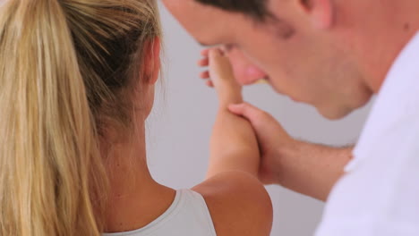 physiotherapist manipulating his patients arm