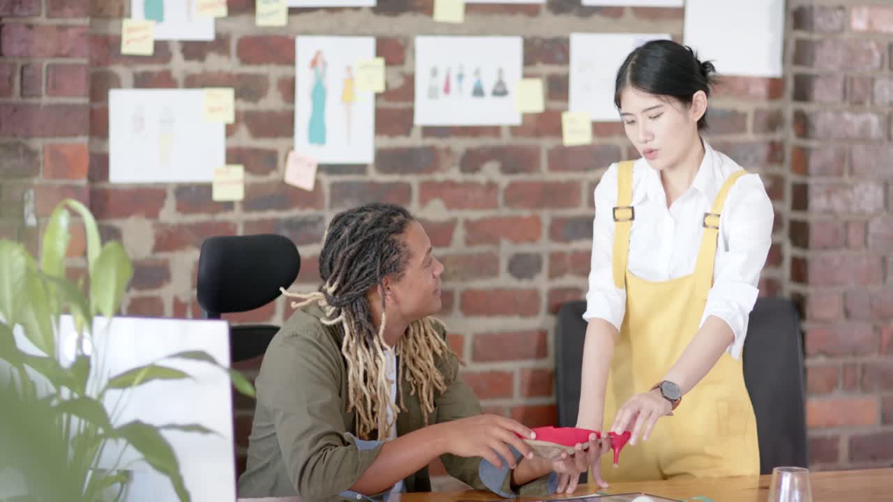 diversos diseñadores ocupados discutiendo el zapato en el estudio de diseño de moda, en cámara lenta