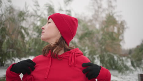 close-up of coach with hands on shoulders turning head slowly to right, snow-covered landscape with frosted trees in background, serene winter outdoor setting