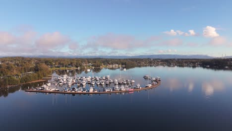 aerial panoramic establishing of trinity point waterfront and marina with boats docked, calm reflective ocean waters