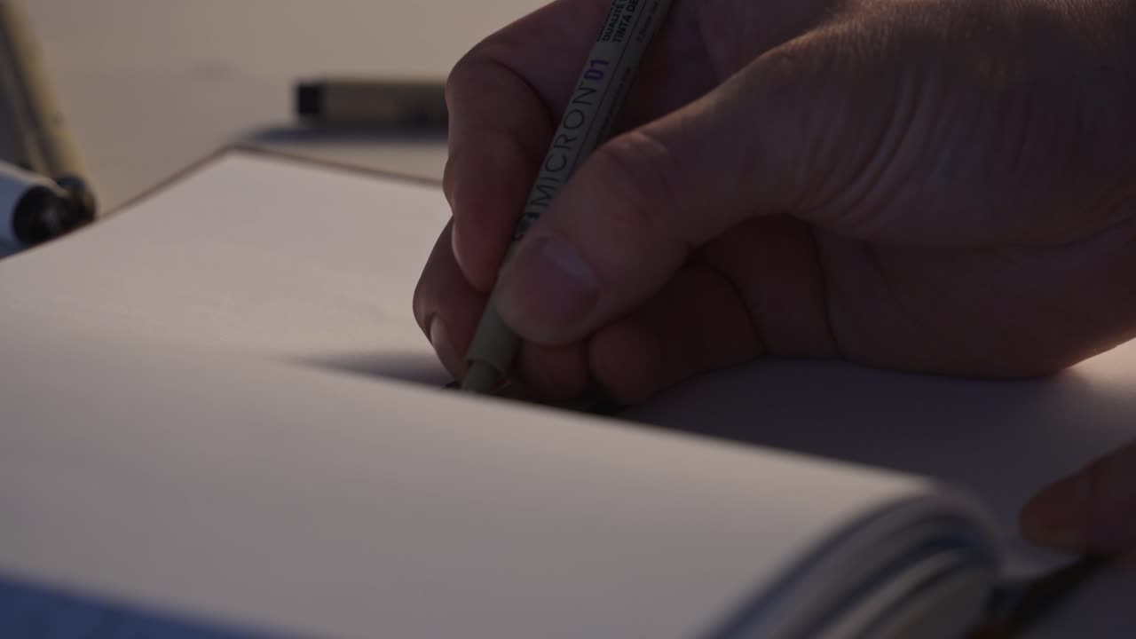 Primo piano delle mani che disegnano linee precise con una matita su carta.