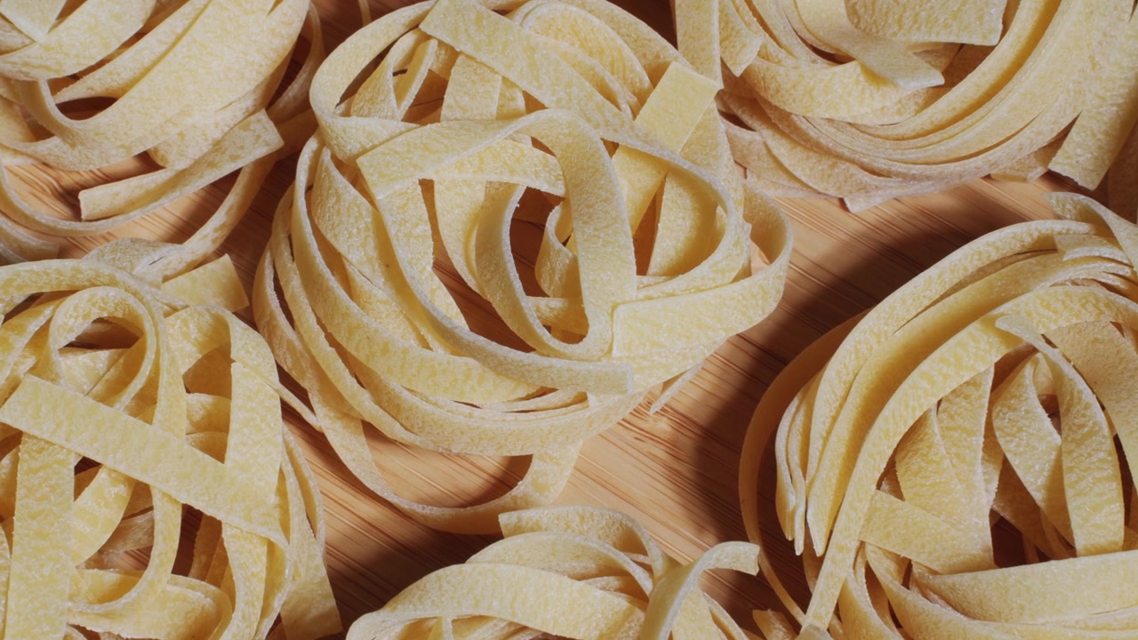 Primo piano di nidi di tagliatelle secche su legno