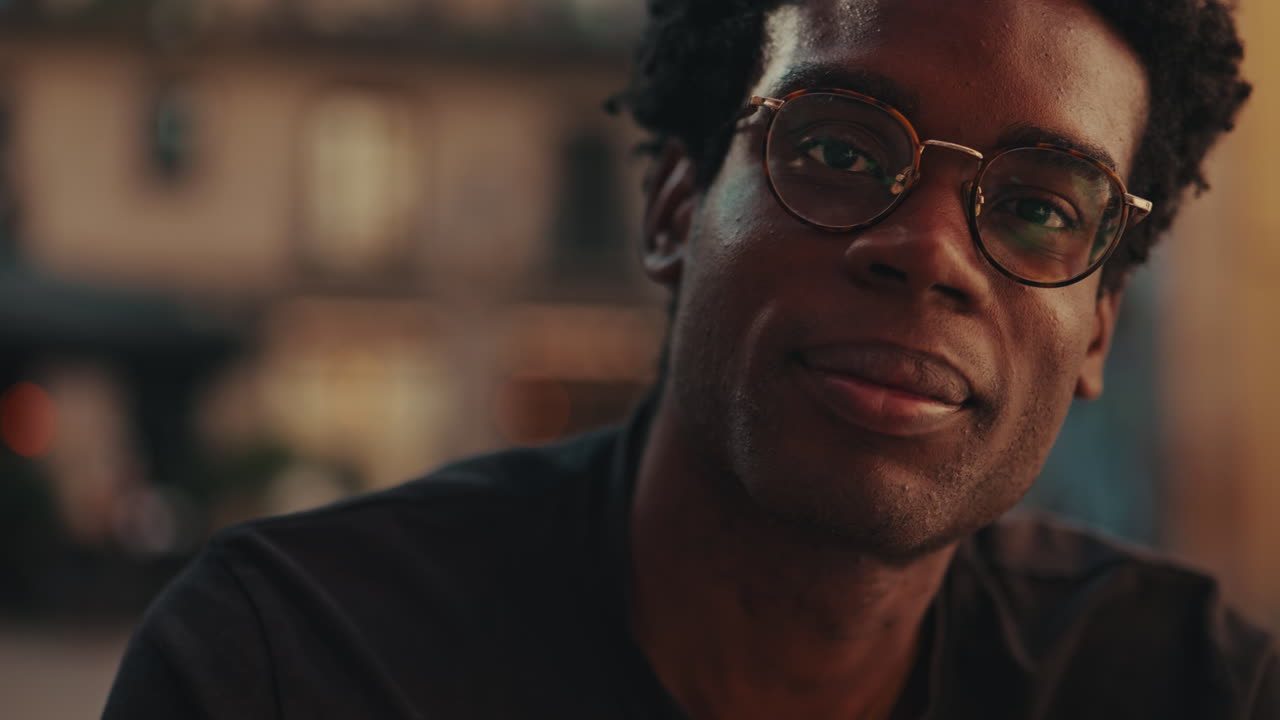 Young Black Man in Glasses Looking Thoughtfully at Camera
