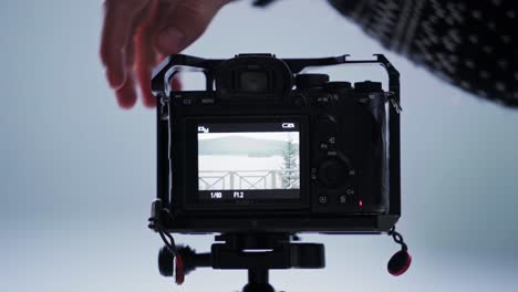 Hand-Setting-Up-Mounted-Camera-To-Take-Picture-Of-A-Lake