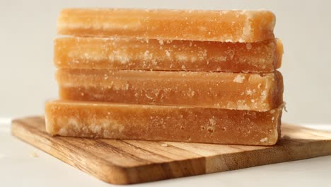 close-up of jaggery blocks on wooden board