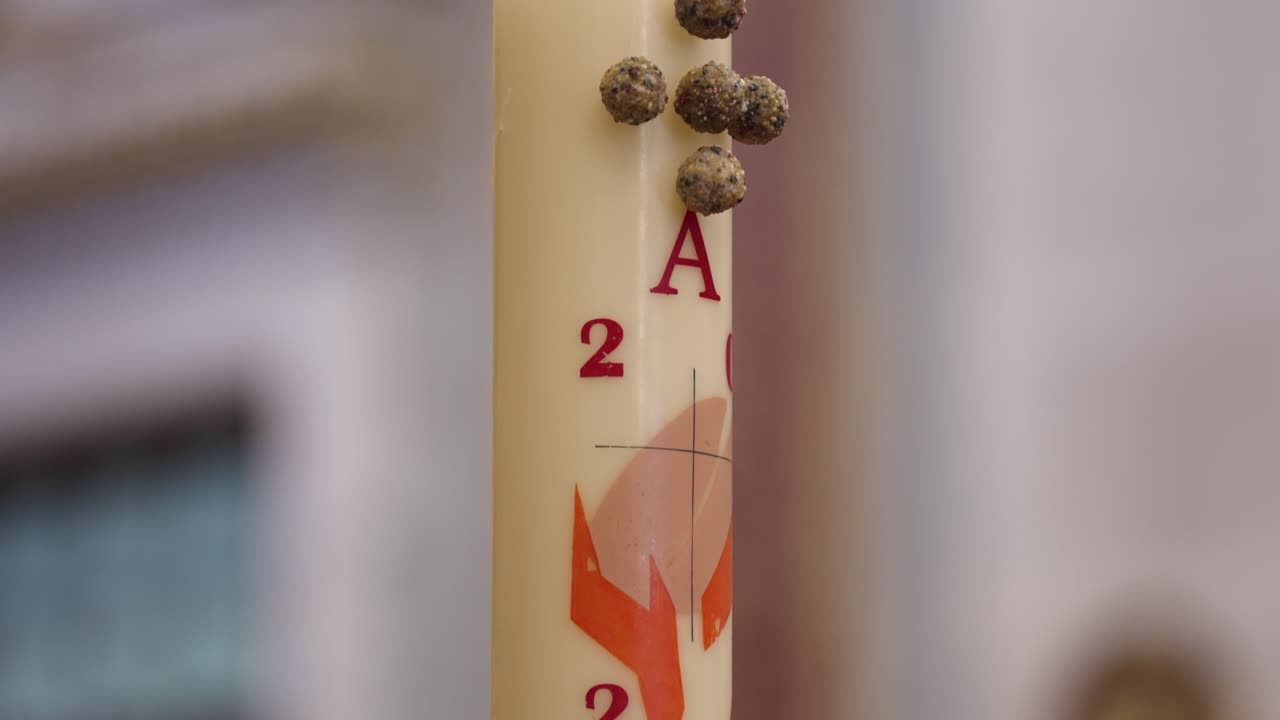 primer plano de una vela litúrgica decorada, utilizada durante ceremonias religiosas con fines simbólicos