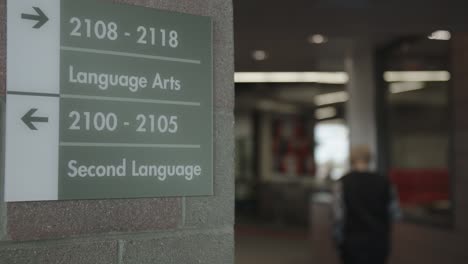 teacher walks past hallway directory in american high school