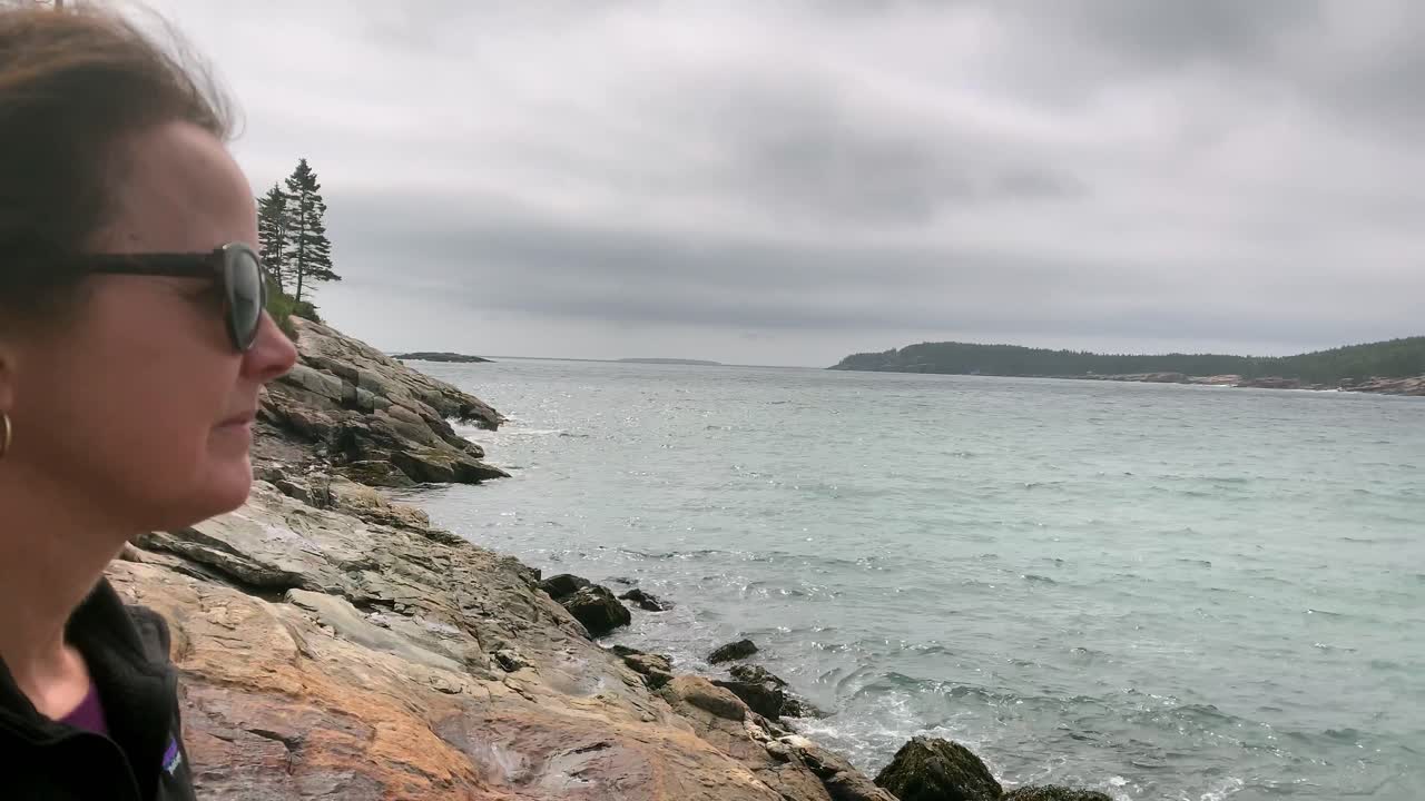 mujer 4k mira la costa de maine