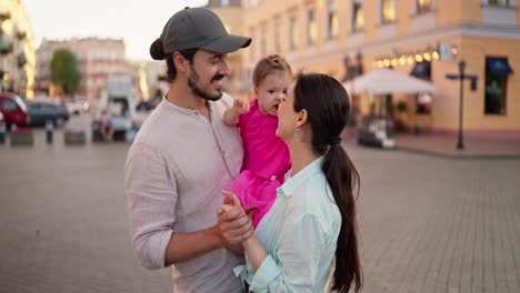 familia feliz de tres caminando por la ciudad