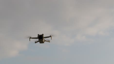 a drone flies smoothly against a cloudy sky