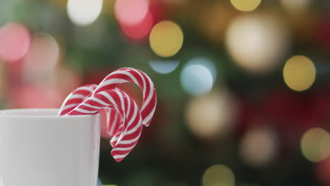 video de taza blanca con bastones de navidad y luces de árbol de navidad con espacio de copia