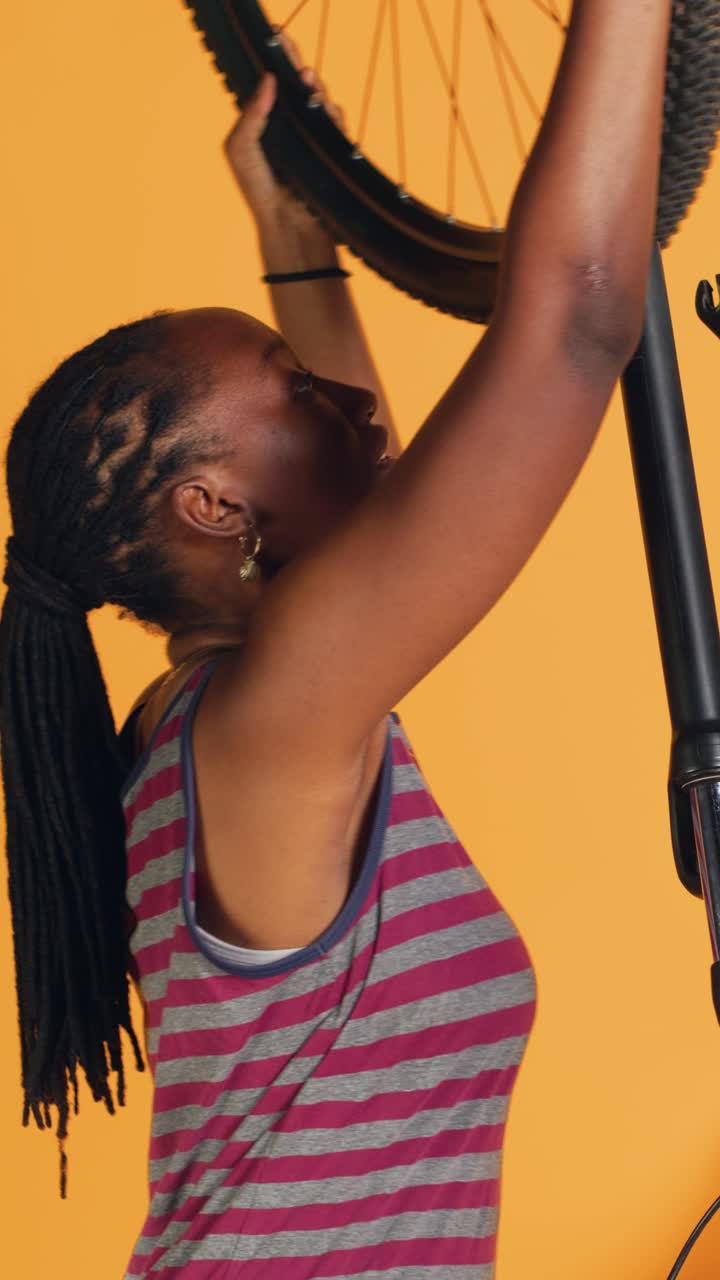 Video verticale Ingegnere che esegue la manutenzione della bici in studio, sostituendo la ruota difettosa