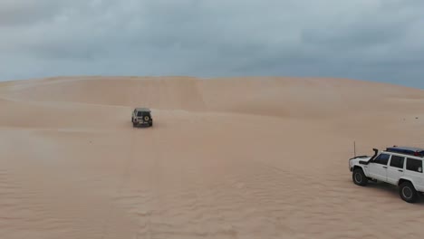 Sigue-A-Un-Automóvil-Que-Conduce-Por-Las-Dunas-De-Australia-Y-Quédate-Atascado,-Aéreo.