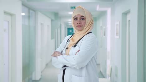 portrait of confident muslim doctor standing crossed hands