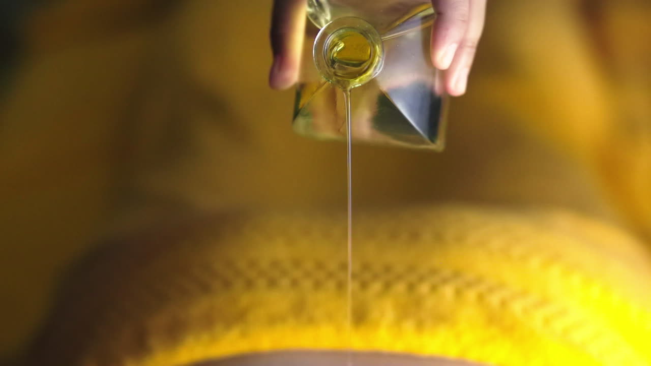 kvinde hælder massageolie på kvinden