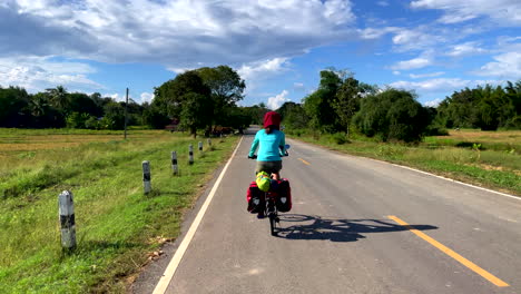 Rear-view-of-women-cycling-in-the-forest-mountain-road-Phitsanulok-city,-Thailand