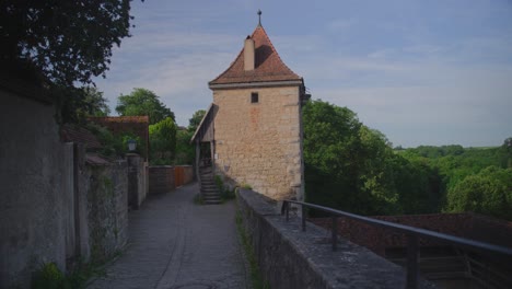 stone tower in rothenburg ob der tauber, a historic german town, surrounded by lush green trees