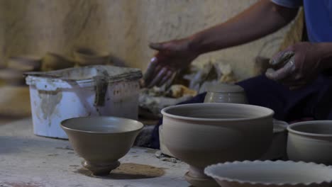 potter surrounded by pots