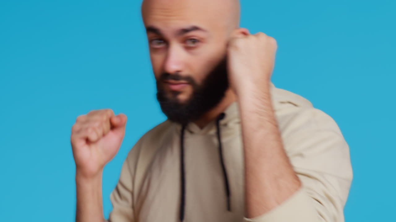 폭력적인 무슬림 사람이 스튜디오에서 주먹을 고 있습니다.