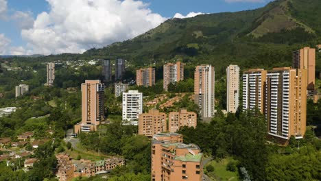 drone descends in poblado, medellin, colombia with beautiful landscape of andes mountains in background