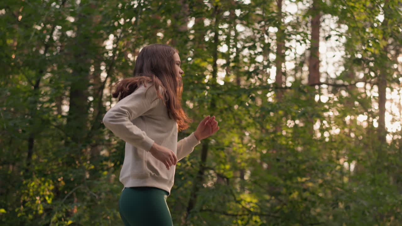 해가 지는 동안 숲에서 조하는 은 머리 여성, 느슨한 머리카락을 가진 여성, 운동선수, 신체 건강을 향상시키기 위해 강렬한 훈련에 참여하고, 자연에서 따뜻한 저녁을 즐기고 있습니다.