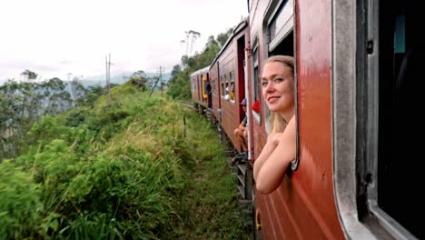 a woman gazes thoughtfully through the window of a moving train traveling the scenic ella to kandy route in sri lanka.