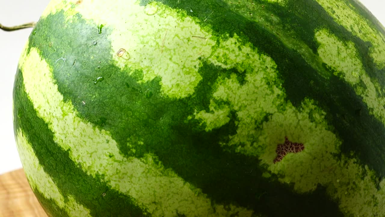 Pastèque sur une planche de cuisine. En mouvement