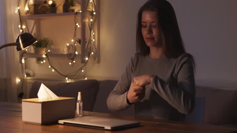 woman sanitizing hands at night