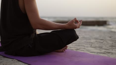 Un-Joven-Practica-Yoga-Y-Medita-En-Una-Alfombra-Deportiva-Mientras-Se-Sienta-Al-Amanecer.-Una-Bandada-De-Pájaros-Vuela-En-El-Fondo.-Tiempo-Libre,-Descanso