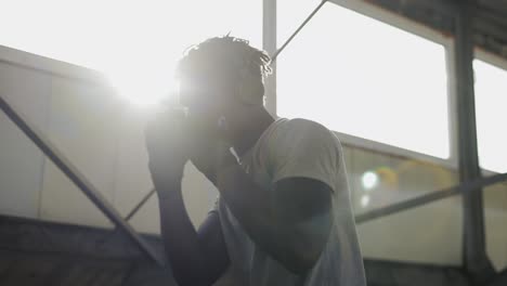 Male-Boxer-Practicing-Shadow-Boxing-Indoors,-Sunlight-Pouring-From-Window