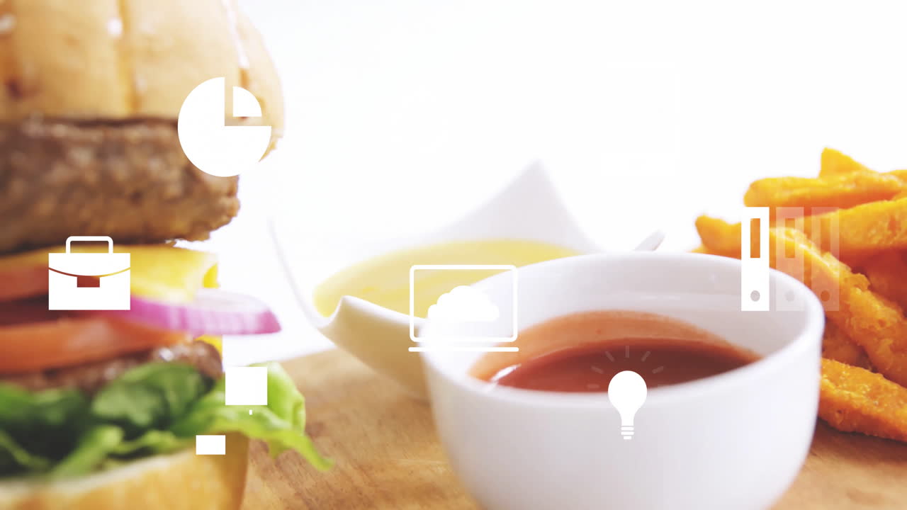Animation of digital icons overlaying burger and fries in food concept