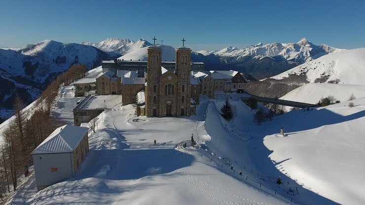 Amazing drone shot flying towards the sanctuary and church la Salette. Snowy