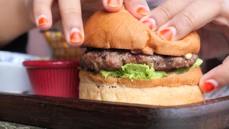 una mujer comiendo una deliciosa hamburguesa.