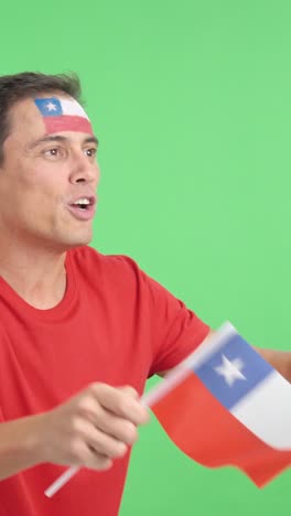 Man cheering for Chile waving a national flag looking away