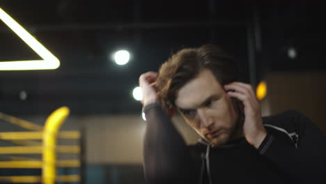 Handsome-male-athlete-exercising-at-gym.-Boxer-warming-up-hands-in-sport-club