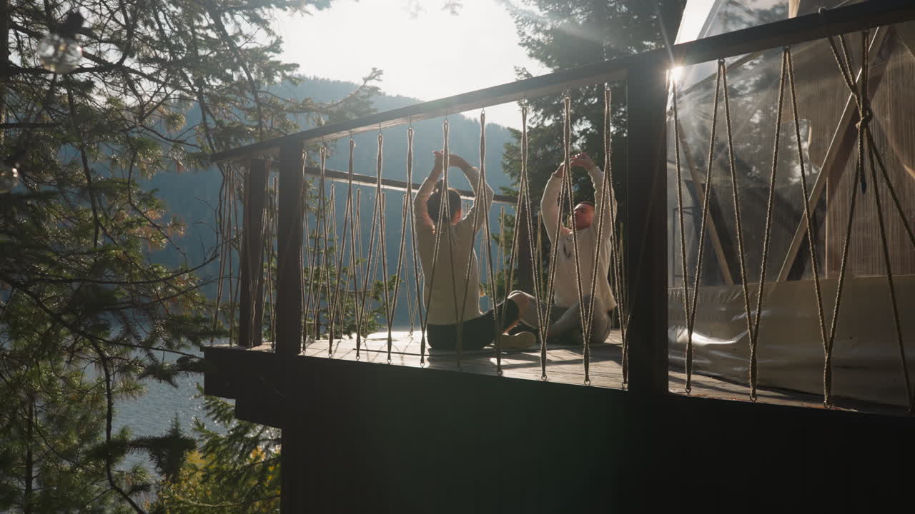 la gente hace ejercicios de respiración en glamping. la mujer lleva a cabo lecciones de yoga para el joven en el lujoso glamping eco resort. los socios disfrutan de la armonía con la naturaleza
