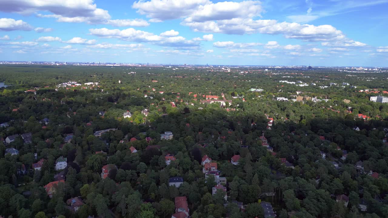 nikolassee, a residential district in berlin, featuring houses nestled within a dense forest, with the city skyline visible on the horizon. Fabulous aerial view flight speed ramp motion time lapse