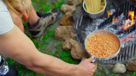 hombres preparando comida en el fuego del campamento en el bosque 4k