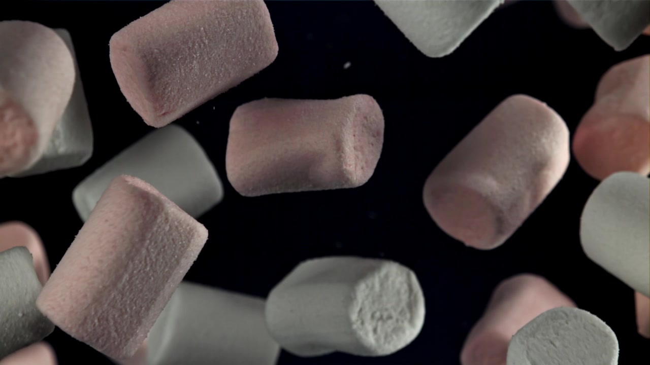 Marshmallow rosa e bianchi che cadono al rallentatore