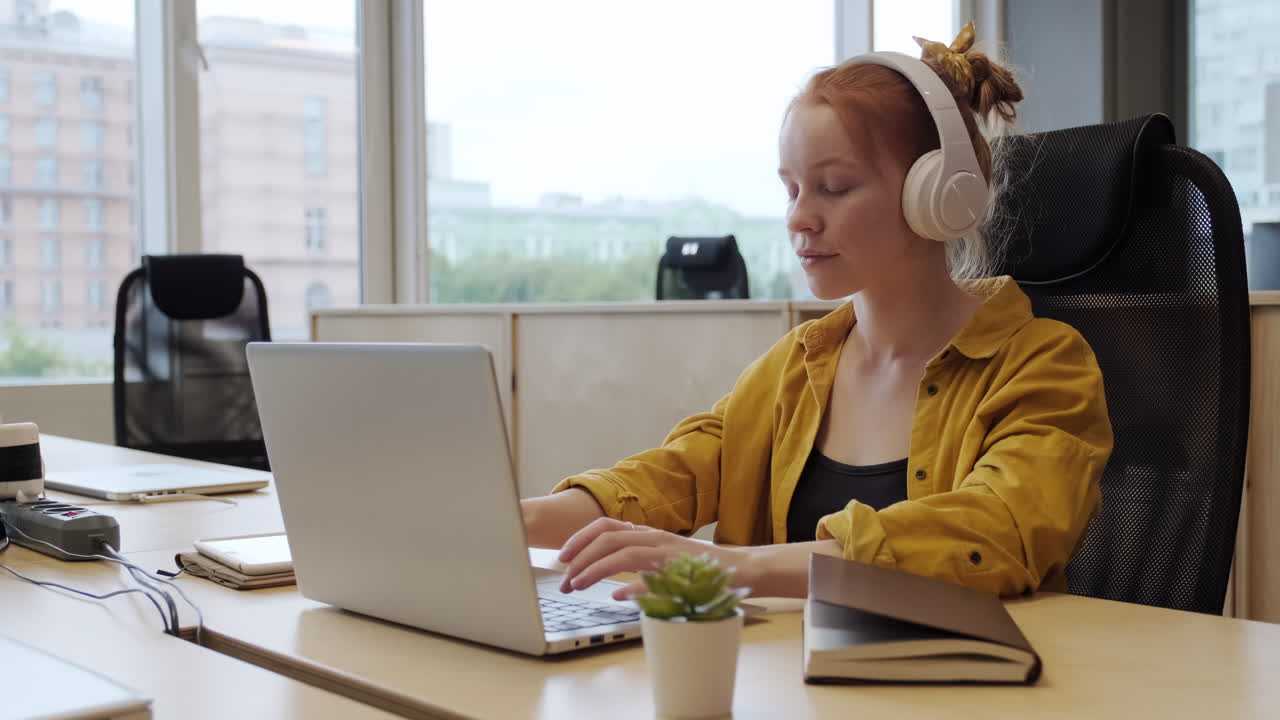 헤드폰으로 노트북을 사용하는 여성