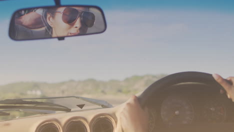 animation of light shade over biracial couple driving car at seaside