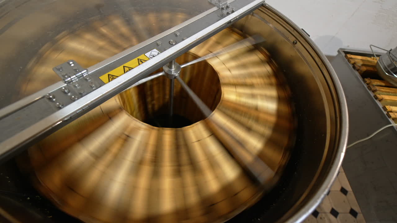 Centrifuge machine spinning the wooden frames to remove organic honey. Electric machine quickly rotating close up. Top view.