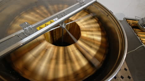 centrifuge machine spinning the wooden frames to remove organic honey. electric machine quickly rotating close up. top view.