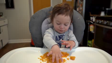 biracial hispanic latino white caucasian baby eating rice in a high chair 4k