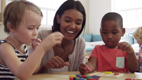 teacher and pupils using wooden shapes in montessori school