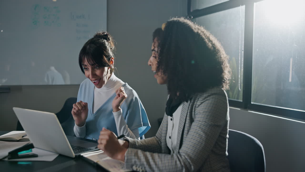 Two Business Women Celebrating Success with High Five in Office