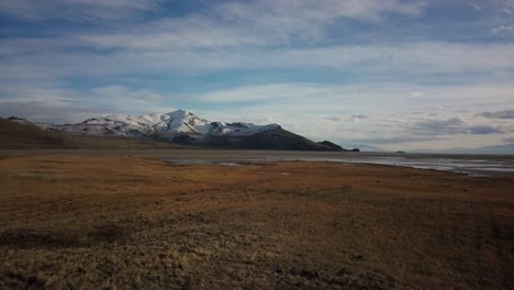 Low-flying-footage-across-a-meadow-and-into-a-marsh-area-to-the-coast-line-of-Antelope-Island-in-The-Great-Salt-Lake-of-Utah