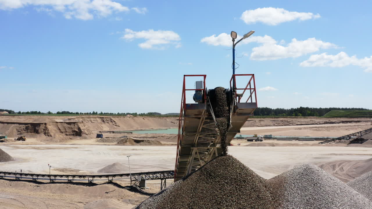 Conveyor Belt Offloading Gravel Into Large Pile At Quarry Site. closeup, drone shot
