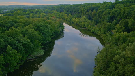 the drone captures a peaceful, slow flight over the huron river in ann arbor during summer.