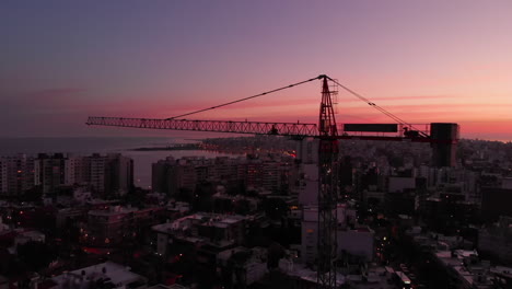 Baukran-In-Der-Stadt-Bei-Sonnenuntergang,-Umlaufbahnaufnahme